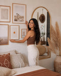 Latina woman in boho bedroom with velvet pillow covers